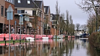Illustratie van een overstroomde woonwijk met water in de straten en zandzakken tegen huizen; gebruikt ter ondersteuning van het in kaart brengen van overstromingsrisico’s met ArcGIS