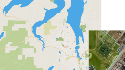 Mapa cinza e verde mostrando grandes massas de água azul e uma foto aérea de uma área rural com estruturas ao longo de uma estrada