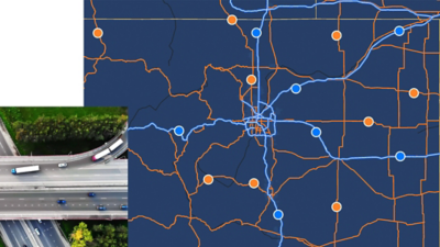 Mapa azul escuro com estradas laranja e azuis e círculos que marcam pontos ao longo das rotas, com uma foto de caminhões semirreboque entrando em uma rodovia
