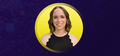 Portrait of Shivon Van Allen smiling in a black camisole with a flat yellow background