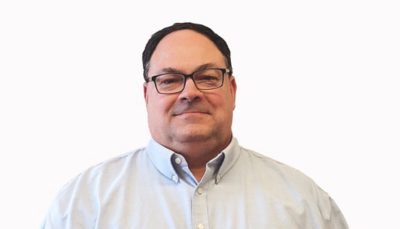 흰색 칼라가 있는 셔츠와 안경을 착용한 채 미소를 짓고 있는 John Borisenko의 사진