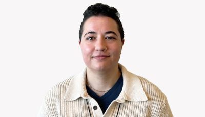 Marie Holler smiling in a cream cardigan in front of a white background