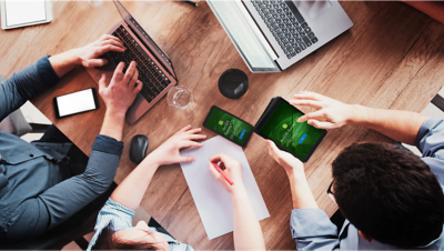 A group of individuals working on surveys on a laptop computer and a mobile device