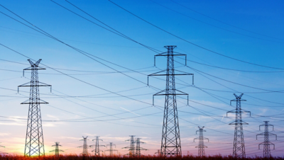 Hoogspanningsmasten en kabels onder kleurrijke lucht