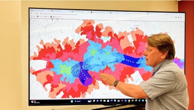 Side view of man pointing at screen where a digitized walkway is shown