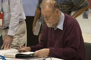 photo of Dr. Roger Tomlinson signing a book