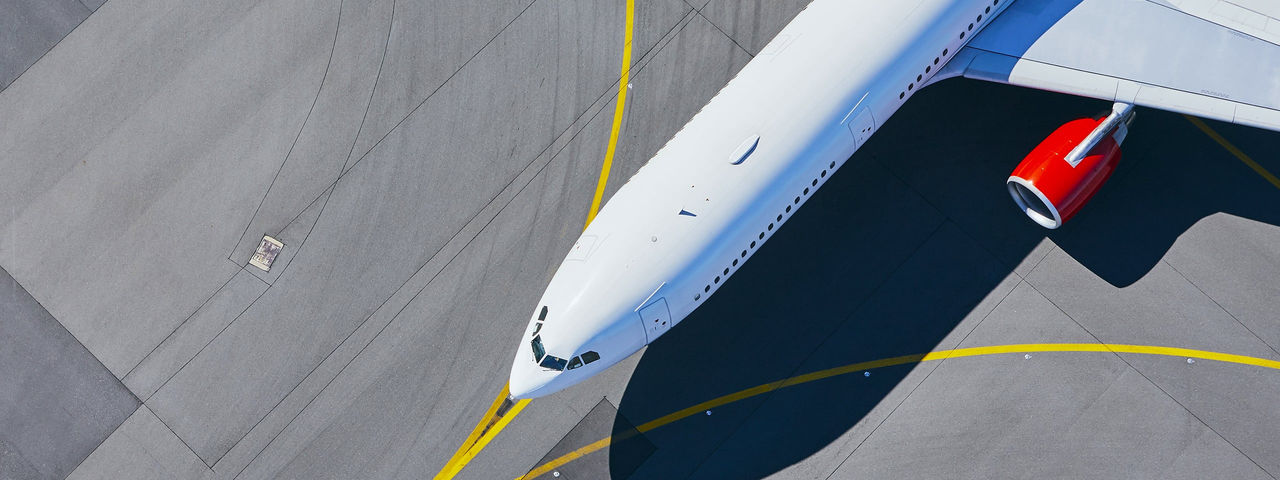Foto aérea da metade frontal de um jato de passageiros no asfalto